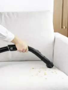 Nettoyer les poussières d’un canapé avec un aspirateur